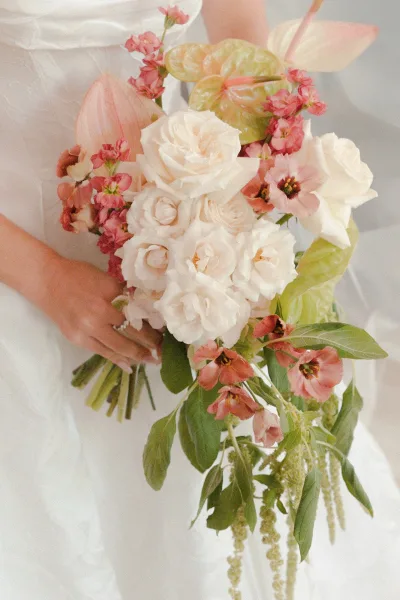Bridal bouquet in a cascading bouquet style featuring anthurium blooms among lush florals, the arrangement softly trailing downward.