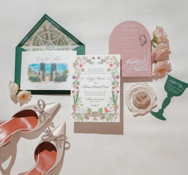 Wedding invitation suite showcasing a floral wedding invitation with a wax seal, artfully arranged on a white textured surface.