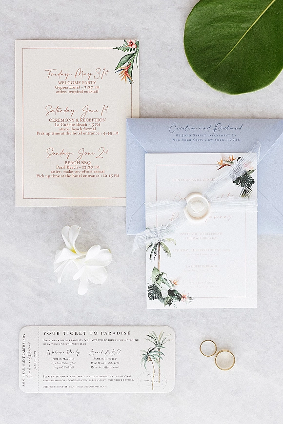 Wedding invitation suite with destination wedding invitations, wax seal, ribbon, RSVP and itinerary cards, gold bands on gray marble flatlay