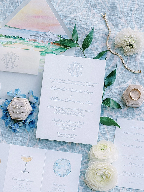 Wedding invitation suite with letterpress wedding invitation, monogram crest, vellum ribbon, rings and blue florals on blue linen fabric
