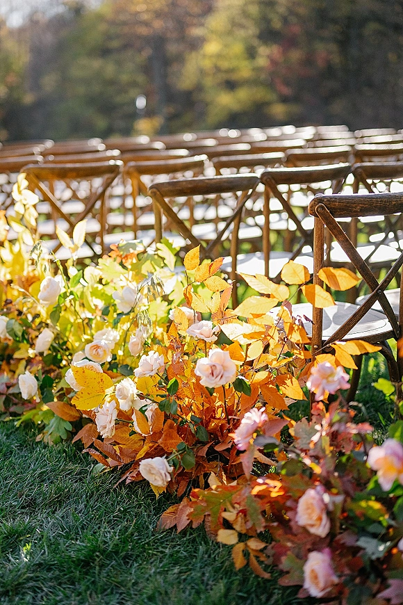 Ceremony aisle decor with outdoor wedding ceremony chairs, wood crossback seating and blush rose ground florals on a garden lawn with trees