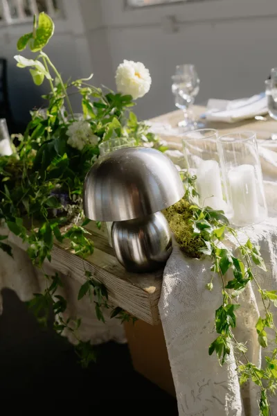 Reception tablescape showcasing a wedding centerpiece idea with a sleek metal mushroom lamp, styled for an elegant indoor celebration.