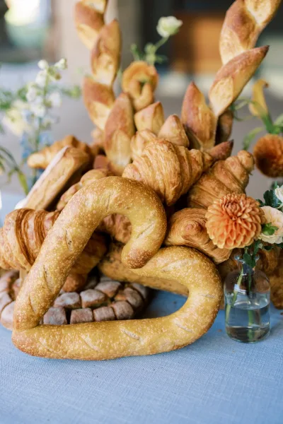 Heart-shaped loaf and dahlias in a bud vase accompany the bread centerpiece at the reception table