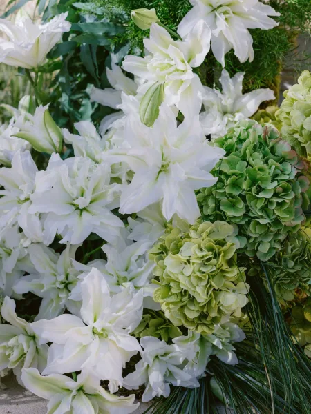 Wedding flowers—green and white wedding flowers highlighted by white lilies, gathered in an elegant, fresh arrangement.