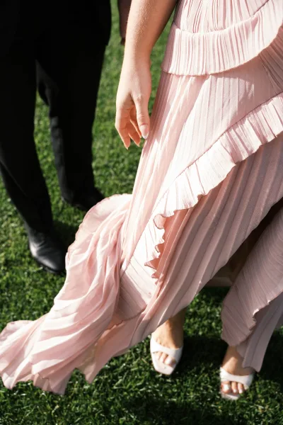 Pleated dress, a blush pink dress that flows gracefully, paired with white heeled sandals for a soft, romantic look.