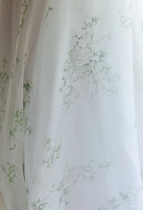 Wedding dress fabric with embroidered tulle wedding dress details, sheer overlay and floral appliqué in soft light close-up