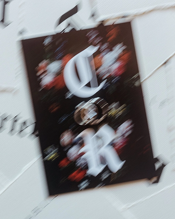 Wedding invitation suite with floral wedding invitation, monogram lettering, envelopes, and wedding rings arranged on a light paper surface