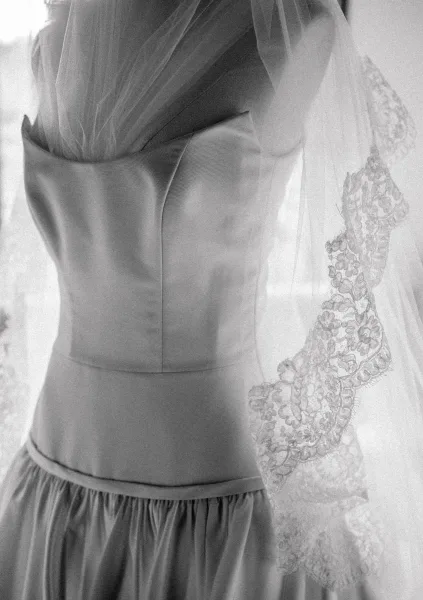Wedding dress detail of a strapless wedding dress with a satin bodice, softly defined by window light.