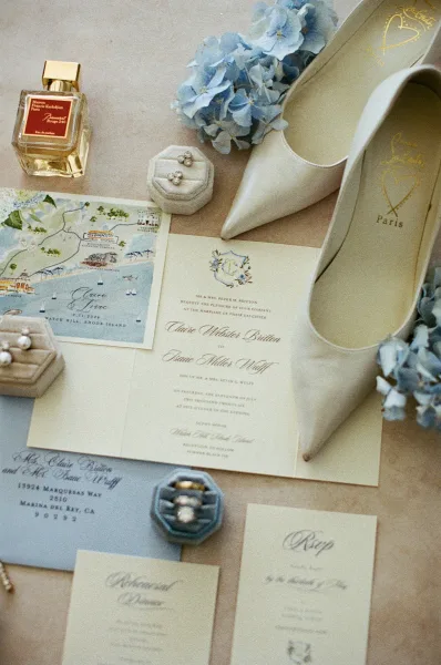 Invitation suite styled as a wedding invitation flatlay, arranged with blue hydrangeas and delicate calligraphy details throughout