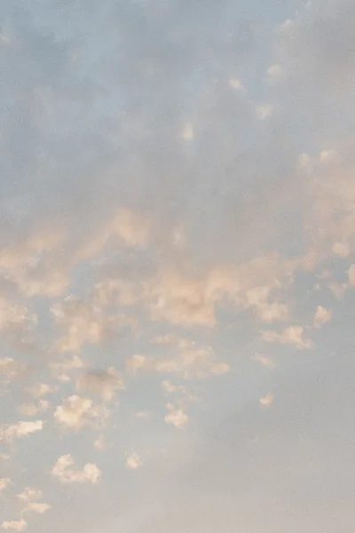 Cloudy sky with pastel sky background, soft evening clouds drifting across pale blue tones in a calm, minimal cloudscape