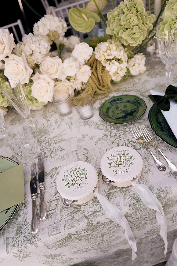 Reception tablescape with green and white wedding table details, white roses, hydrangea, taper and votive candles, crystal flutes on green toile linen