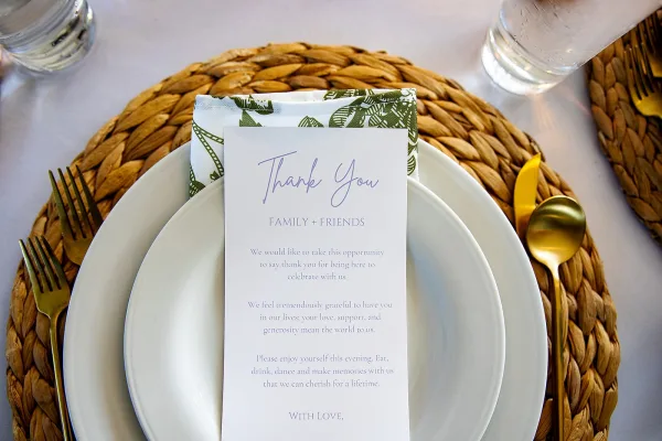Wedding place setting showcasing a woven charger plate, arranged with minimalist elegance and soft, natural texture for a refined reception detail.