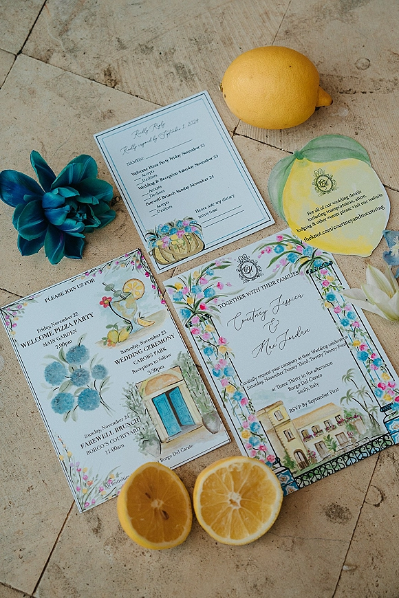 Wedding invitation suite with watercolor wedding invitations, lemon and floral illustrations, RSVP and details cards, vellum envelope and wax seal on stone tile surface