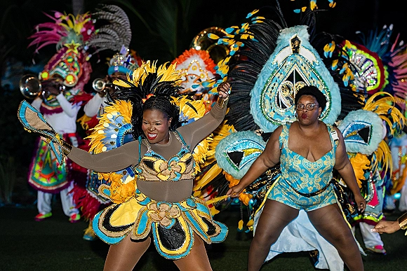 Wedding second line performers in New Orleans second line wedding parade, dancing on a nighttime lawn in sequined feather headdresses