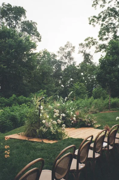 Outdoor ceremony setup with garden ceremony decor arranged on a wooden platform, ready for vows in an open-air space.
