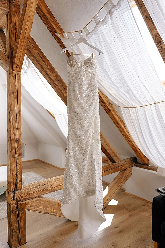Wedding dress, sequin wedding dress with strapless sweetheart neckline on hanger in rustic loft attic with window light