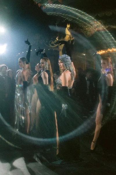 Reception entertainment with a wedding dance performance by dancers in sequined gowns, set before a carousel horse among the guests.