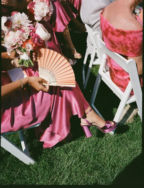 Bridesmaid dresses—magenta bridesmaid dresses—paired with bouquets on a grass lawn for a bold, cohesive look