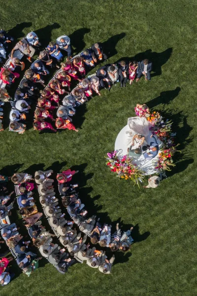 Ceremony seating design features curved ceremony seating around a circular platform on a grass lawn, creating an intimate gathering.