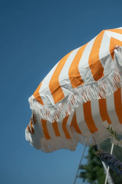 Striped umbrella with playful fringe trim, this fringe umbrella spreads a wide canopy of crisp stripes, shading an inviting outdoor scene.