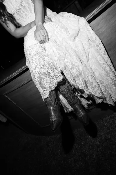 Bridal cowboy boots paired with a lace wedding dress, highlighting a wedding dress with boots look and rustic bridal charm.