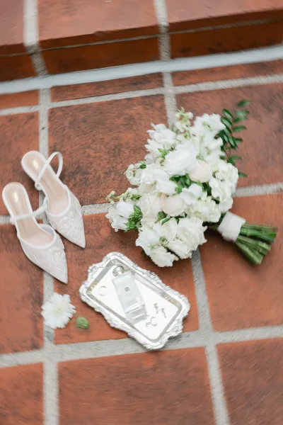 Wedding details flat lay featuring bridal accessories centered on a silver tray atop a terracotta tile stair step, arranged with refined balance.