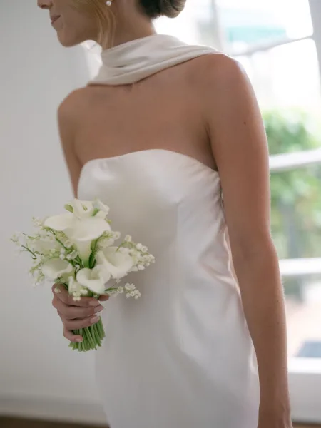 Bridal bouquet, a small calla lily bouquet held by the bride, with creamy trumpet-shaped blooms gathered neatly in a posy.
