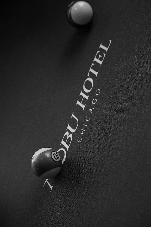 Pool table detail with wedding billiards balls resting on felt, tightly framed against a dark tabletop surface