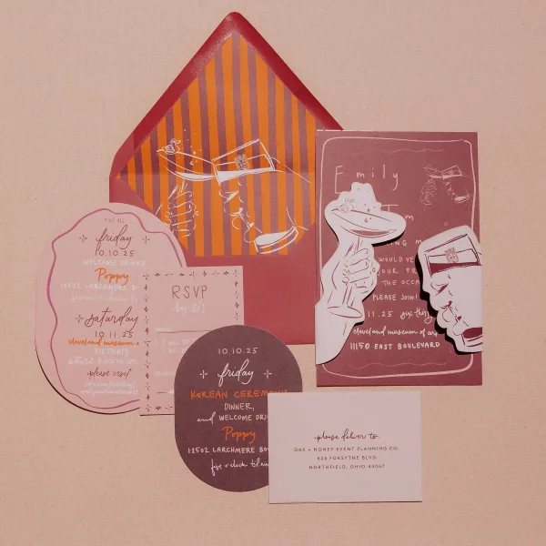 Wedding invitations suite with envelopes, RSVP and details cards, die-cut illustrated inserts, and striped liners on linen backdrop
