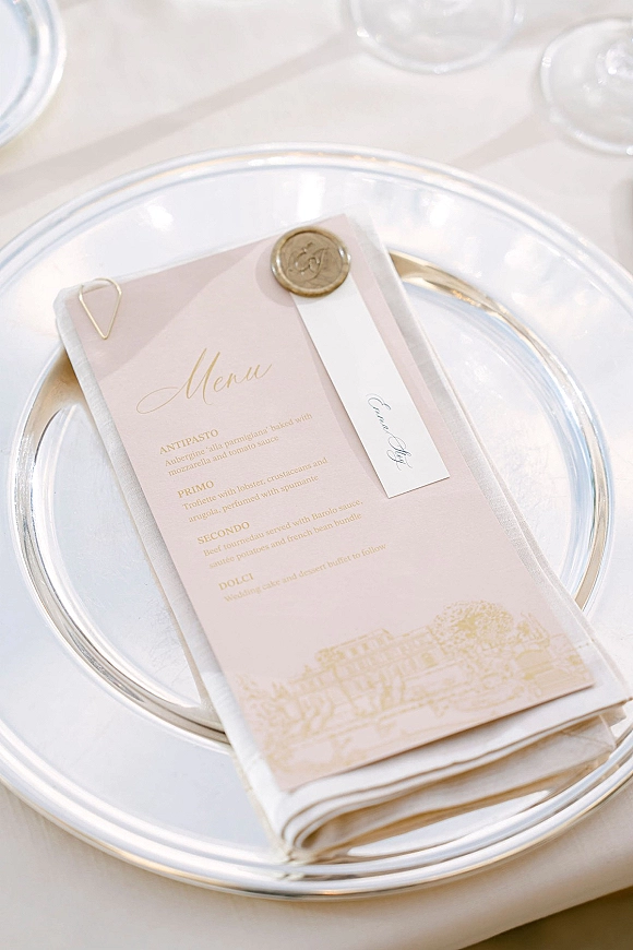 Wedding menu card with wedding menu design in blush calligraphy, paired with a wax seal place card on a white reception table setting