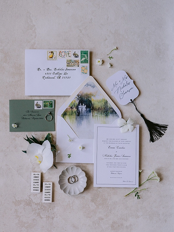 Invitation suite wedding invitation flat lay with envelopes, wax seal, postage stamps, rings and orchid on a neutral stone surface