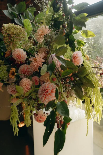 Wedding floral arrangement featuring dahlia wedding flowers with trailing amaranthus in an organic, asymmetrical garden style display.