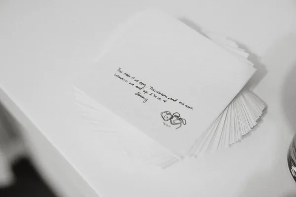 Custom wedding napkins double as love note napkins, featuring a handwritten quote for a romantic, minimalist detail at cocktail hour