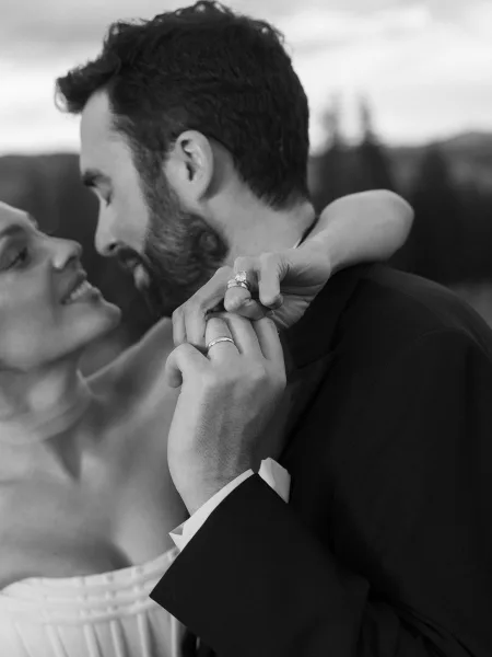 Couple portrait of a bride and groom embrace, her strapless bridal gown flowing as they hold close in a tender moment