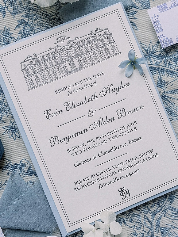 Save the date card with wedding save the date details, calligraphy names and blue envelope liner on blue-and-white floral fabric, with ribbon accents