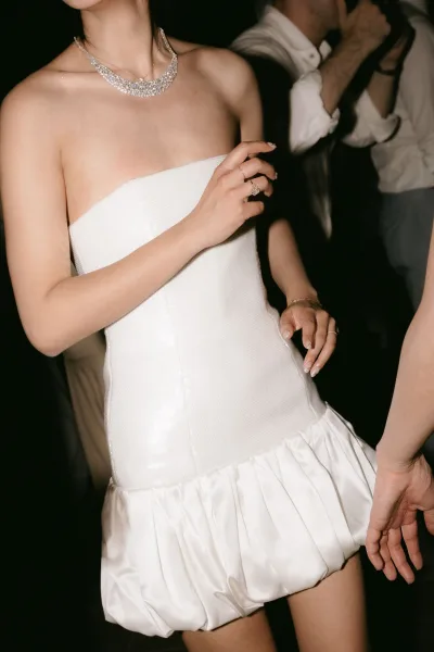 Mini wedding dress with a strapless bridal mini dress silhouette, paired with a delicate necklace, highlighting clean lines.