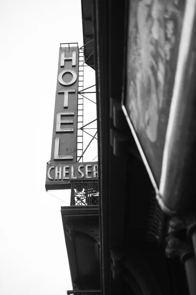 Venue signage on a hotel exterior detail, a vertical sign affixed to the building exterior in an architectural detail view.
