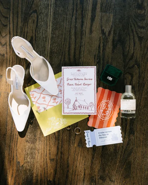 Invitation suite arranged as a wedding stationery flat lay, highlighted by a green velvet ring box for a touch of texture.