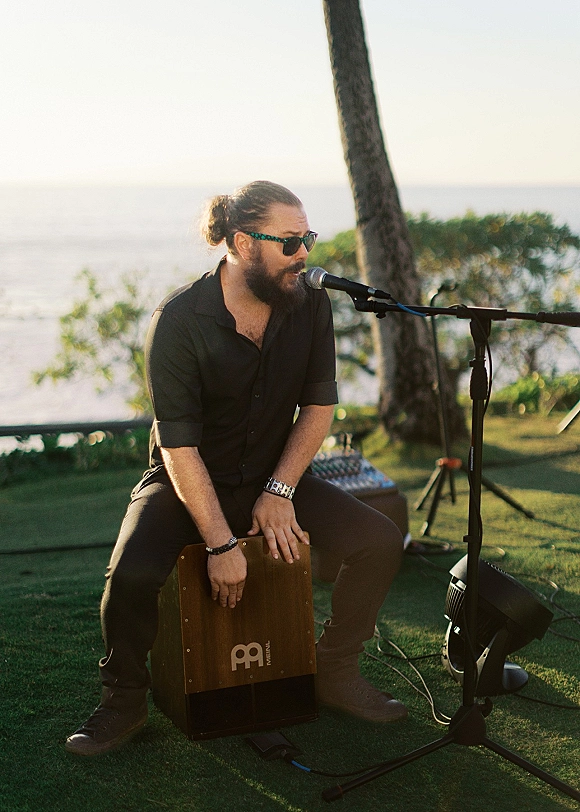 Wedding musician performing live music wedding ceremony with a microphone stand and speaker on a lawn overlooking the ocean view