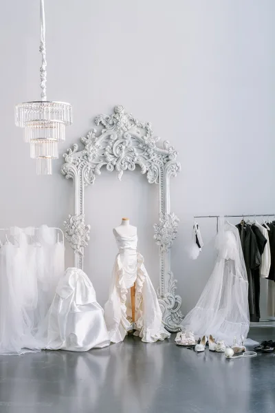 Wedding dress display featuring a gown beside a mannequin, set against a light gray wall and polished concrete floor.