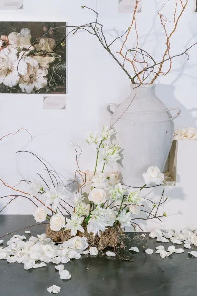 Wedding floral arrangement featuring white rose wedding flowers arranged in a ceramic urn, styled with an open, airy composition.