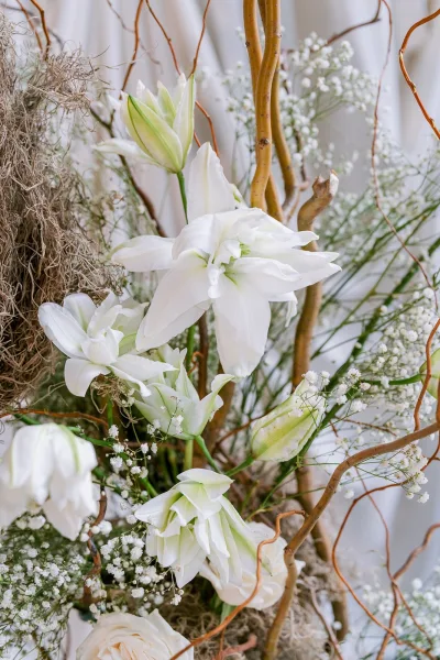 Floral arrangement of white wedding flowers featuring lilies, shaped with natural lines for a sculptural, airy look.