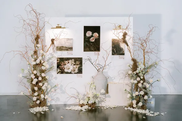Wedding floral installation showcasing a graceful white rose installation with curly willow branches arranged in an airy, asymmetrical form.