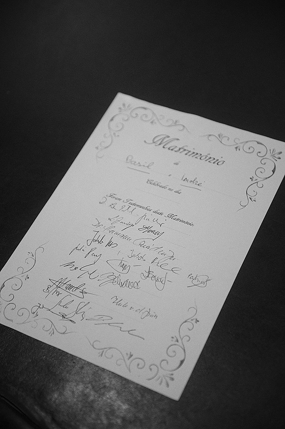 Wedding certificate with ornate border and calligraphy text, signed at the bottom, resting on a dark leather surface for a vintage feel
