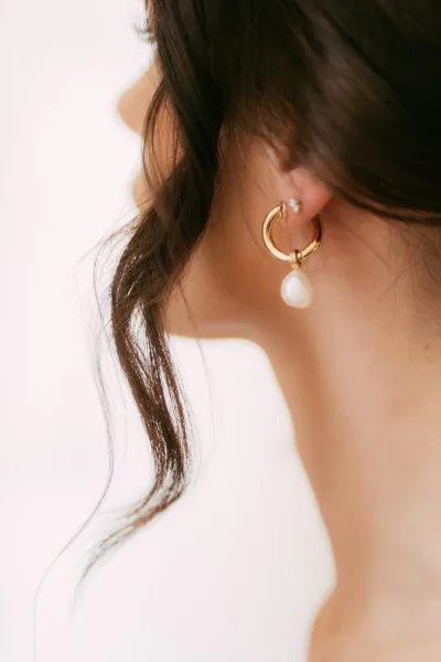 Pearl drop earring on a gold hoop, an elegant take on pearl drop earrings styled as bridal earrings, delicate and timeless.