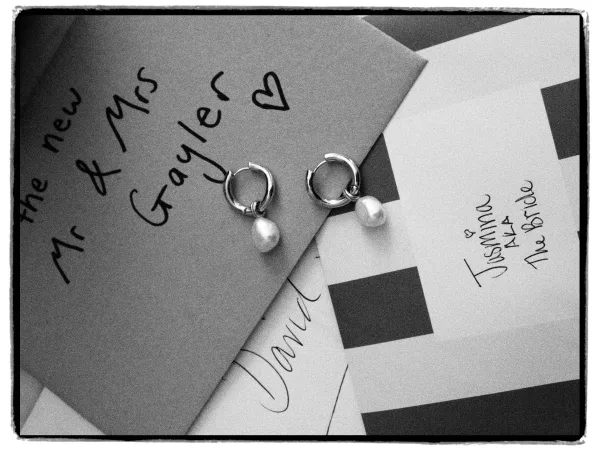 Bridal earrings, delicate pearl drop earrings arranged in a flatlay with handwritten stationery and a neutral color swatch card