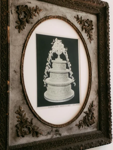 Wedding cake illustration in an antique frame, a refined piece of vintage wedding cake art showing a classic three-tier design in black and white.