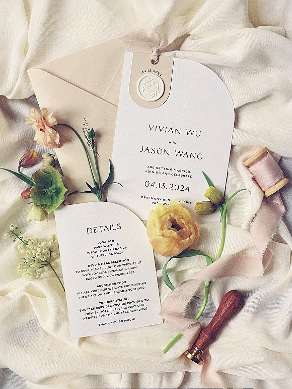 Invitation suite wedding invitation flat lay with round card, envelope, ribbon and wax seal, styled with flowers on white fabric backdrop