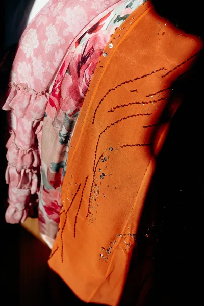 Wedding guest outfit featuring a floral wedding guest dress with beaded embroidery and ruffle details, shown against a dark interior backdrop