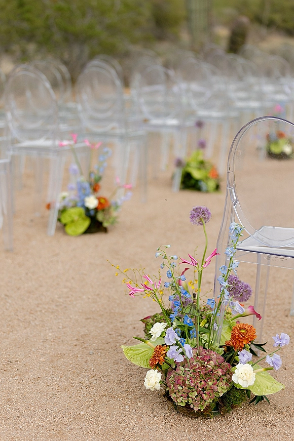 Ceremony aisle decor with wedding aisle flowers in meadow-style ground arrangements of hydrangea, allium and delphinium on gravel path